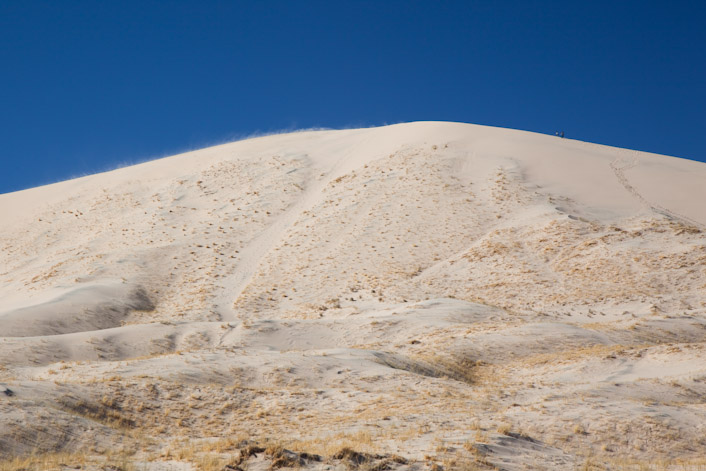 Hikers on the top with blowing sand